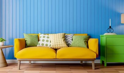 apartment with bright blue wall, yellow couch and green dresser