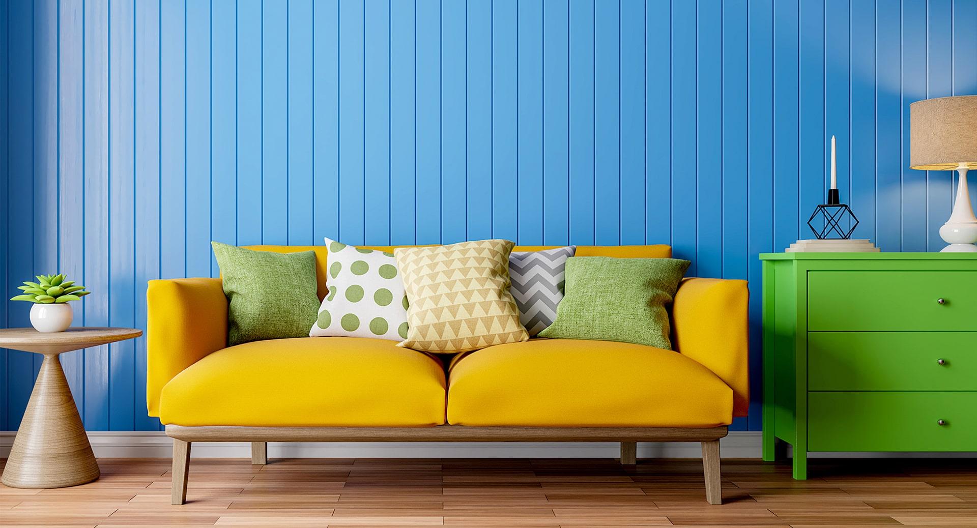 apartment with bright blue wall, yellow couch and green dresser