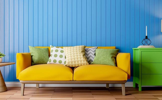apartment with bright blue wall, yellow couch and green dresser