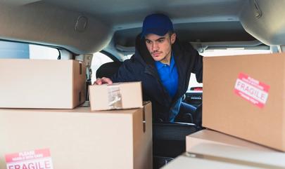courier checks a package before delivering to package room