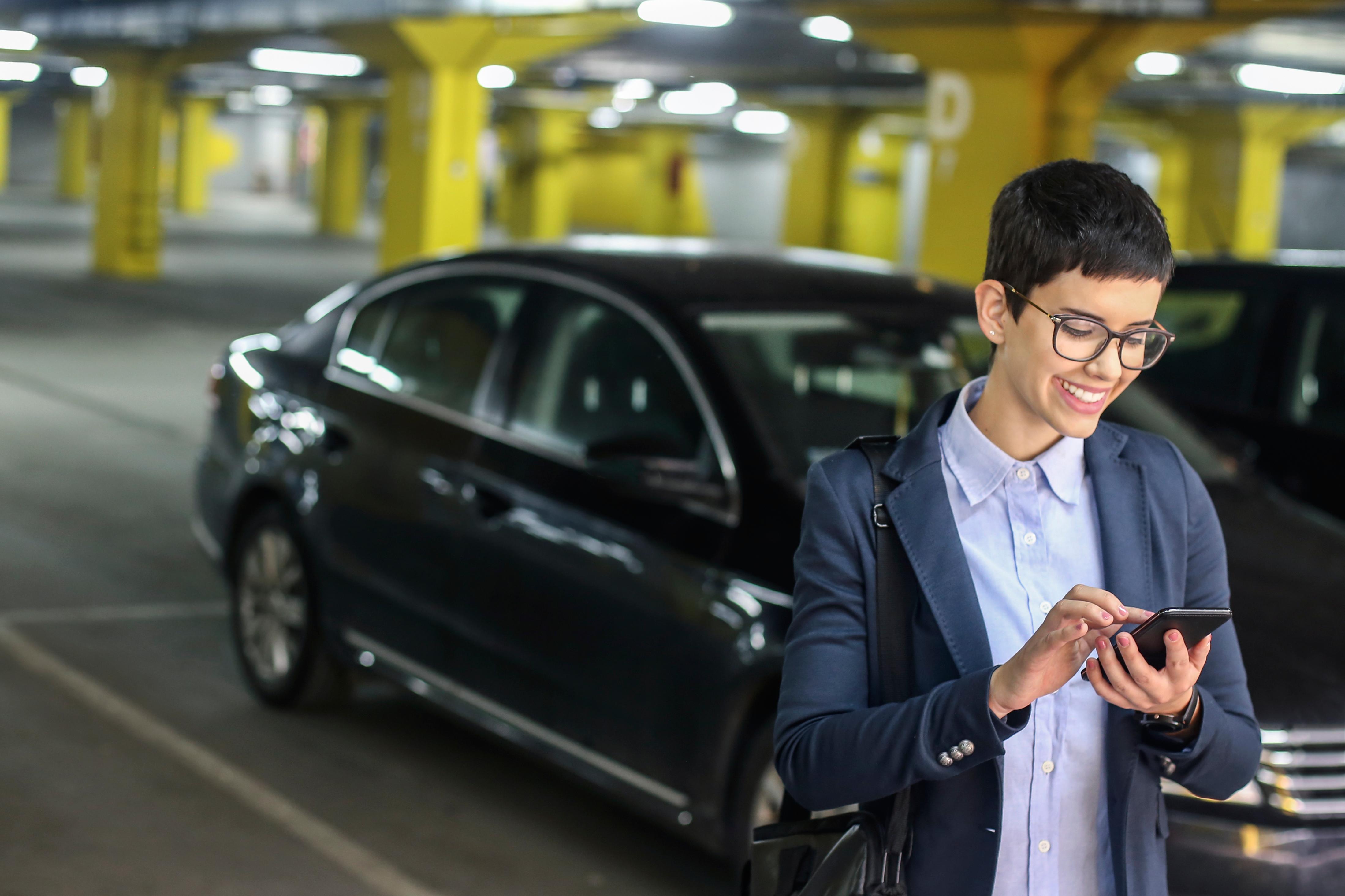 woman smiling at her phone inside parking garage
