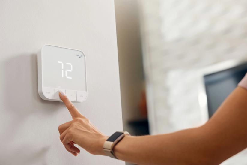 Apartment resident adjusts their smart thermostat