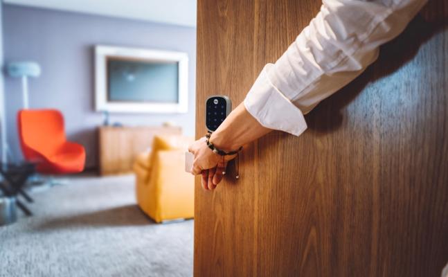 person entering a home with smart lock on the door