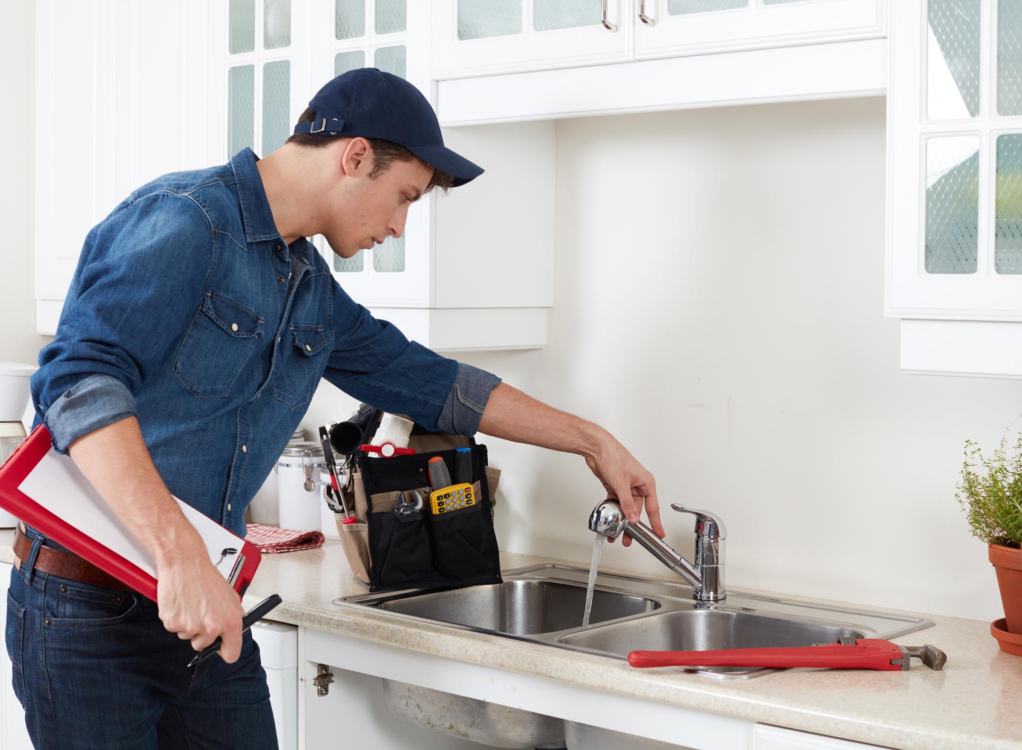 A maintenance technician repairs sink in a multifamily apartment home.