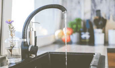 Image of a kitchen faucet with running water