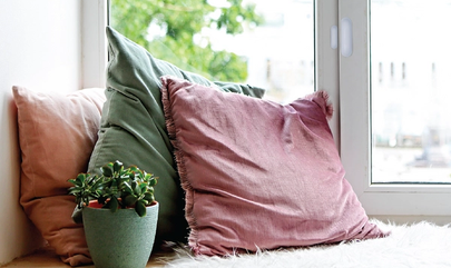 close up of contact sensor mounted on a window with bench and pillows below